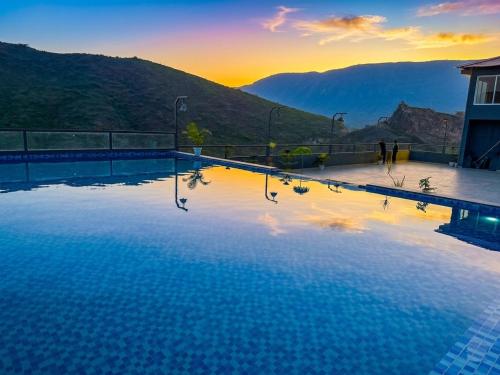 a swimming pool with a view of a mountain at The Divine Hills Resort Suites with Private Pool Near IIM Udaipur in Nāi