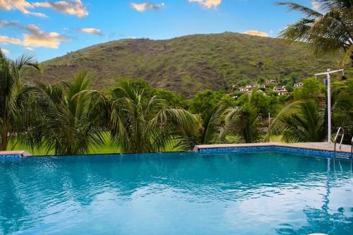 a swimming pool with a mountain in the background at The Divine Hills Resort Suites with Private Pool Near IIM Udaipur in Nāi