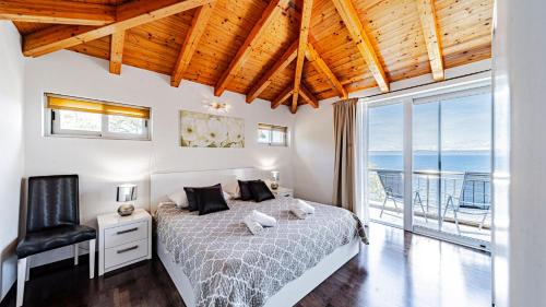 a bedroom with a bed and a large window at Villa Antonia by Villas Guide in Blato