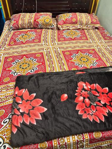 a bed with a bedspread with flowers on it at Lara Homestay 1bhk Begumpet in Hyderabad