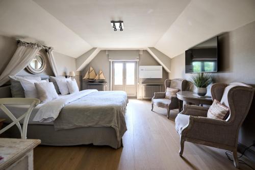 a bedroom with a bed and a living room at Lebeaubylivingroom Hotel in Knokke-Heist