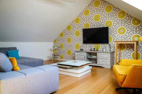 a living room with a couch and a tv at IDDup Atrium in Oreye