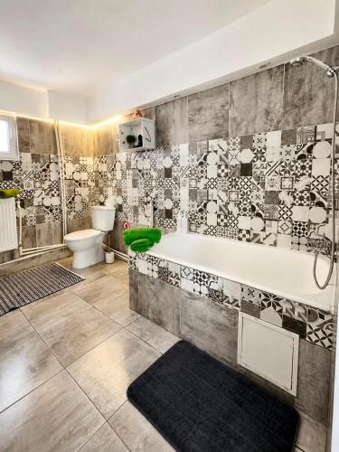 a bathroom with a tub and a toilet at Casa Family in Eforie Sud