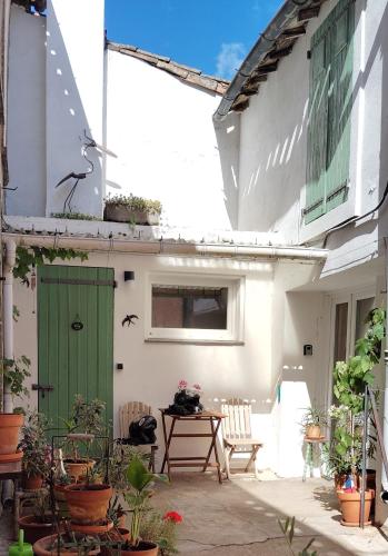 a courtyard of a house with a green door and chairs at Self contained private gite close to Carcassonne, rural location in Badens