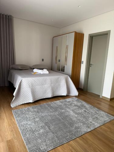 a bedroom with a bed and a large rug at Studio Liv in Sorriso