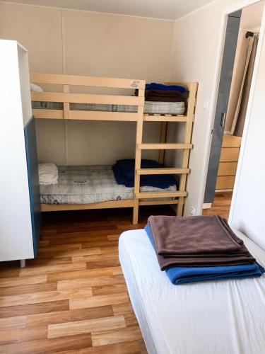 a room with two bunk beds and a wooden floor at Camping La Bernede in Rennes-les-Bains