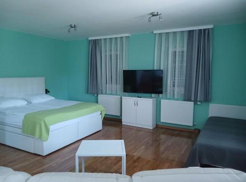a bedroom with a bed and a flat screen tv at Villa Lika in Plitvička Jezera