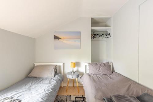 a bedroom with two beds and a table with a lamp at Explore the west in Loughrea