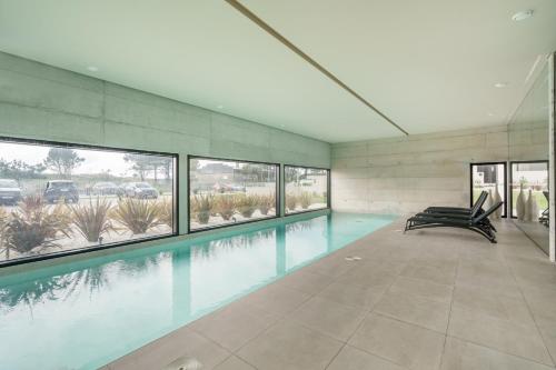 a large swimming pool in a building with windows at Seaside Beach Condo by Minho's Guest in Apúlia
