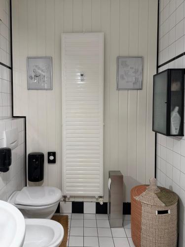 a white bathroom with a toilet and a sink at Apartment Luk - Design trifft Zuhause in Furth im Wald