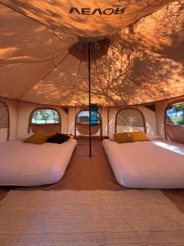 a room with two beds in a tent at Agriturismo Barattis in Piombino
