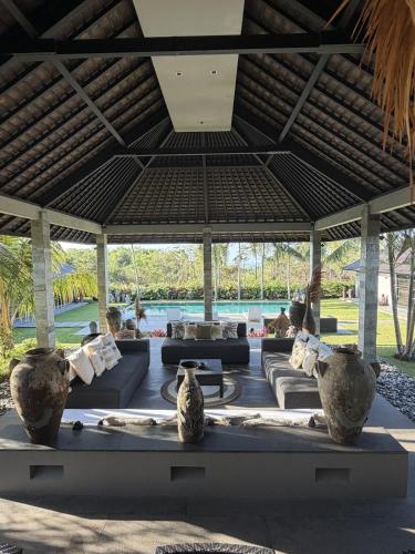 a large living room with couches and a table at Life is One in Uluwatu