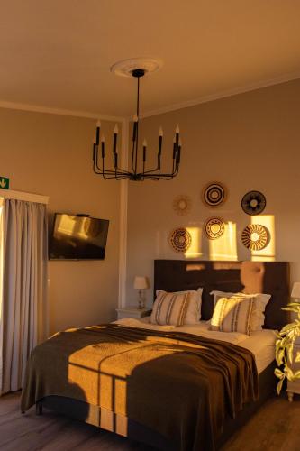 a bedroom with a large bed and a chandelier at Mörk Superior Cottages in Hvammstangi