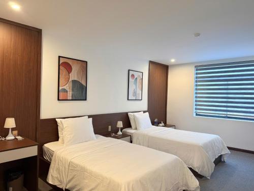 a hotel room with two beds and a window at Minh Hai Hotel Lao Bao in Lao Bao