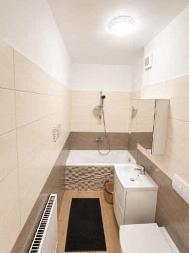 a bathroom with a tub and a toilet and a sink at Magda's Apartments in Braşov