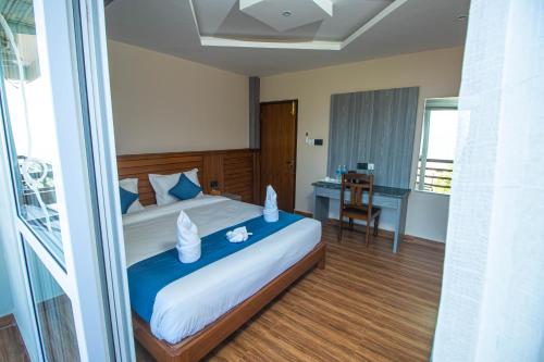 a bedroom with a large bed and a desk at Himalaya Forest Resort in Deorāli