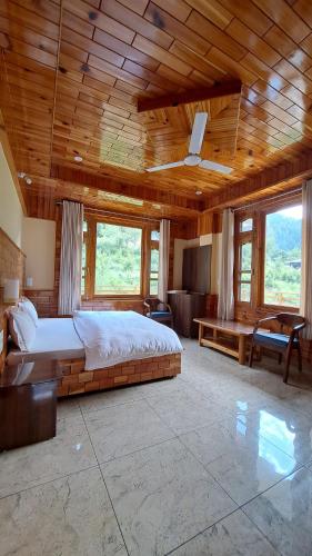 a large bedroom with a bed and a wooden ceiling at Himalayan Hideaway Homestay in Kasol