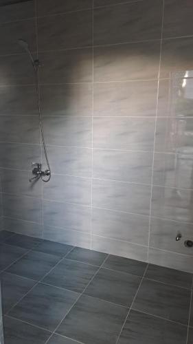 a bathroom with a shower with a tiled wall at Old Rooms in Sheki