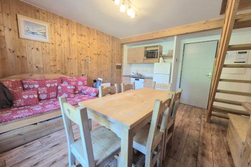 a kitchen and dining room with a wooden table and chairs at Chalet MÖKI accès piscine sauna in Les Déserts