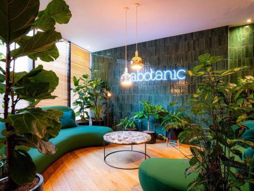 a room with plants and a couch and a table at Mercure Paris Montparnasse Pasteur in Paris