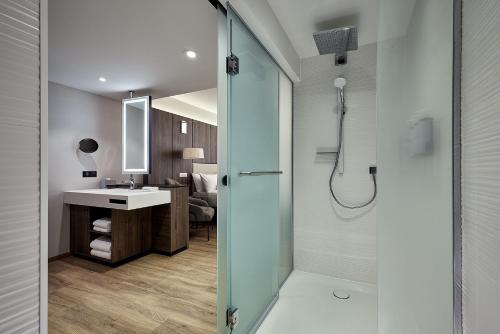 a bathroom with a shower and a sink at AC Hotel by Marriott Strasbourg in Strasbourg