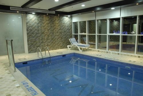 a swimming pool in a house with a chair next to it at Al Hayat Hotel Suites in Sharjah