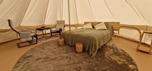 a bedroom with a tent with a bed and a rug at Kempingas Prie Vencavų malūno in Viencavai