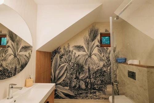 a bathroom with a wall mural of palm trees at Magiczne Roztocze in Koszele