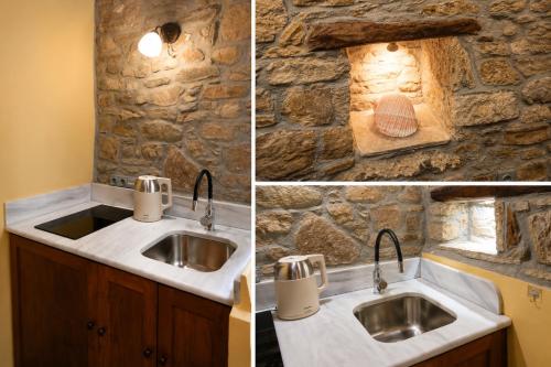 a bathroom with a sink and a stone wall at Thetis Stone Residence in Volissos