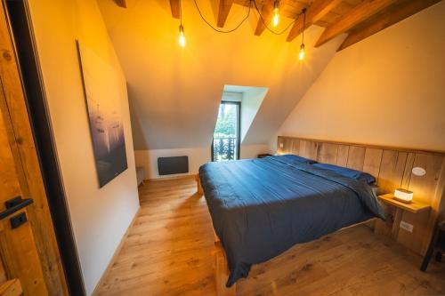 a bedroom with a blue bed in a attic at Châlet Haut de Gamme Pyrenees in Guchan