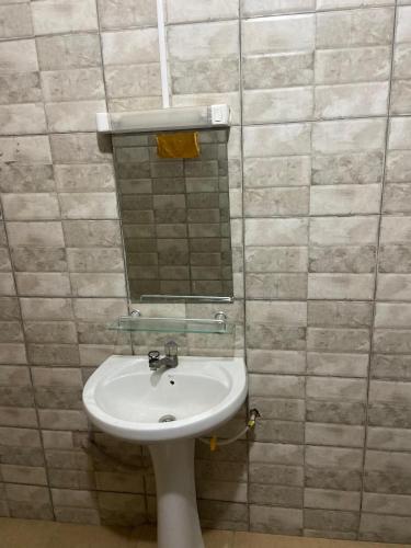 a bathroom with a sink and a mirror at New ACROPOLE in Komé