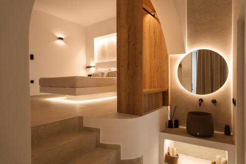 a bedroom with a bed and a mirror at Ios Panoramic Sea view stylish suite with pool in Tzamaria
