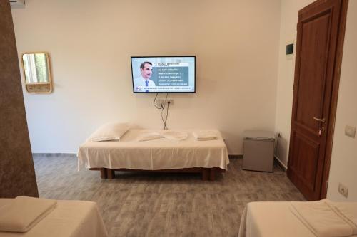 a room with a bed and a tv on the wall at Agora Apartments in Dhërmi