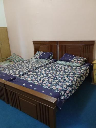 a bedroom with a bed with a blue floor at Whispering Fields in Abbottabad