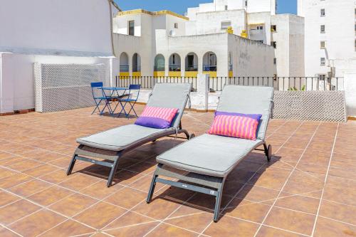 two chairs with colorful pillows sitting on a patio at Marbella Village in Marbella