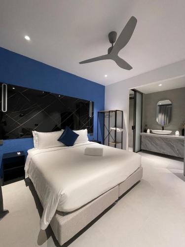 a bedroom with a large bed with a ceiling fan at Velaa Dhigurah in Dhigurah