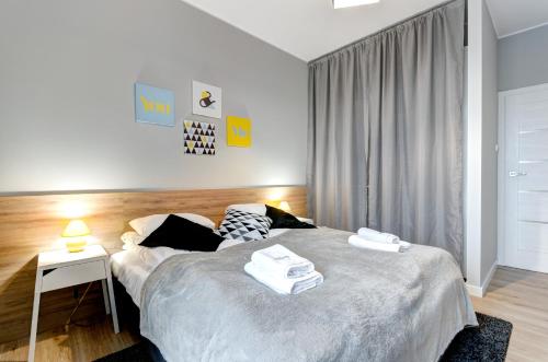 a bedroom with a bed and a table with a lamp at Dom & House - Apartments Brabank Old Town in Gdańsk