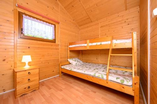 a bedroom with bunk beds in a log cabin at Domki i pokoje nad morzem U Izy Jarosławiec in Jarosławiec