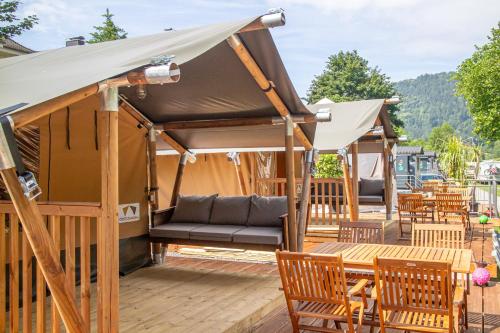 a gazebo with a couch and tables and chairs at Camping Neckargemünd bei Heidelberg in Neckargemünd