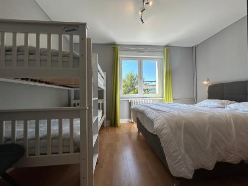 a bedroom with a bunk bed and a window at Appartement RDC Chalet à 300m du lac de Gérardmer in Gérardmer