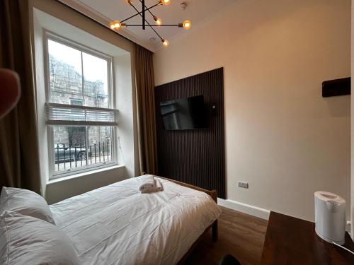 a bedroom with a bed and a tv and a window at Super Nova Self-Service Hotel in Aberdeen