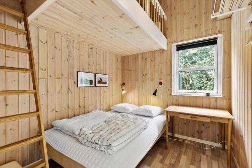 a bedroom with a bed in a wooden wall at 8522-Grenaa-Nobilisvej-15 in Grenå