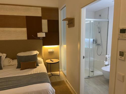 a bedroom with a bed and a bathroom with a shower at Soller Plaza in Sóller
