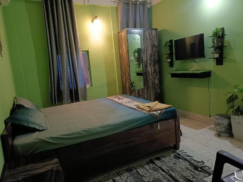 a bedroom with a bed and a flat screen tv at SH Homestay in Tezpur