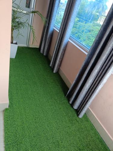 a room with green flooring in front of a window at SH Homestay in Tezpur