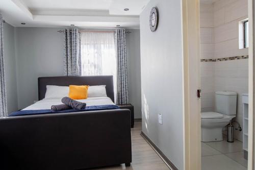 a bedroom with a bed and a toilet at Red Pillar in Maseru