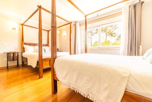 a bedroom with two beds and a window at Villa Praia e Floresta in Aroeira