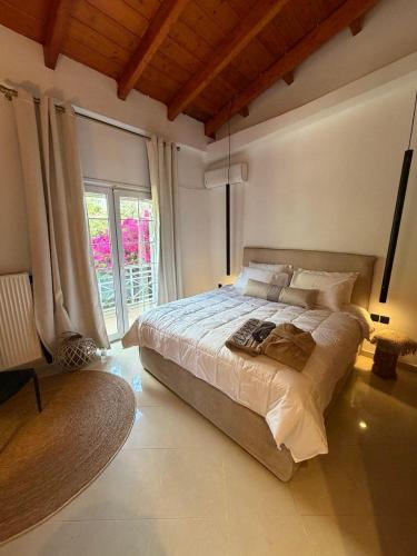 a bedroom with a large bed and a large window at Casa Blue in Panayía Mesosporítissa