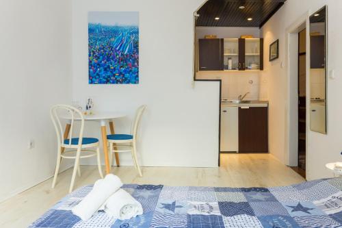 a bedroom with a bed and a table and a kitchen at The heart of Dubrovnik in Dubrovnik