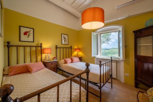 a bedroom with two beds and a window at Villa Caterina 8, Emma Villas in San Gimignano